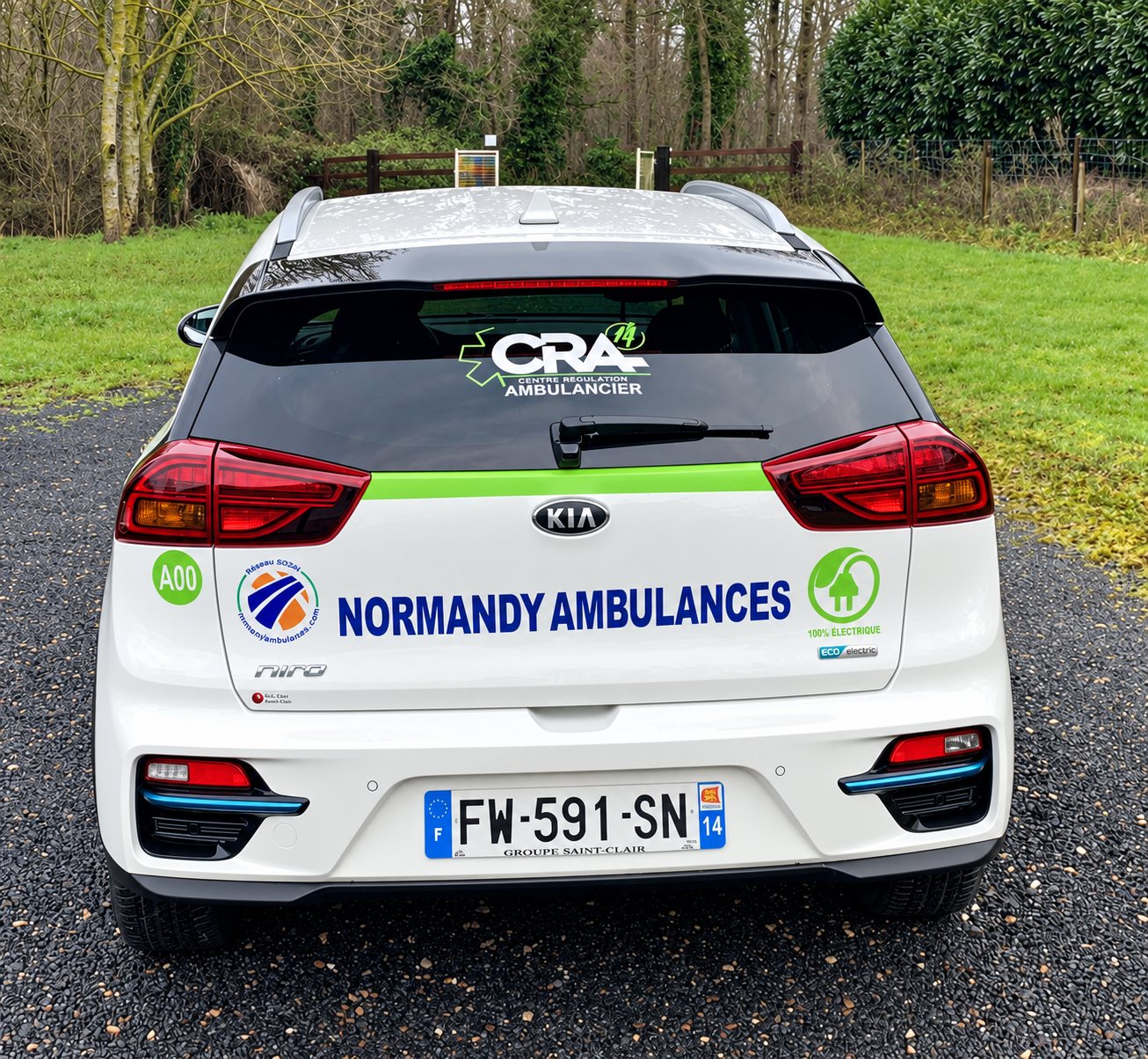 Kia e-Niro électrique blanche de Normandy Ambulances vue de l’arrière, avec le logo CRA et la mention 100 % électrique